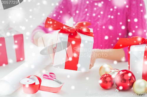 Image of close up of woman decorating christmas presents