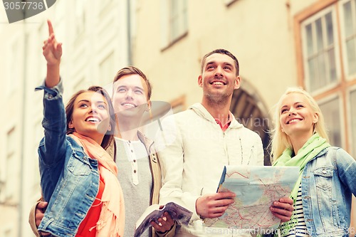 Image of group of smiling friends with city guide and map