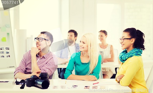 Image of smiling team with photocamera working in office