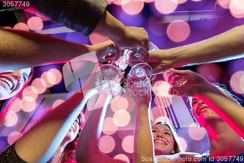 Image of smiling friends with glasses of champagne in club