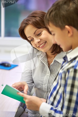 Image of school boy with notebook and teacher in classroom