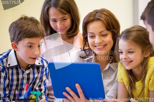 Image of group of kids with teacher and tablet pc at school