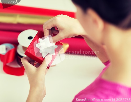 Image of close up of woman decorating christmas presents