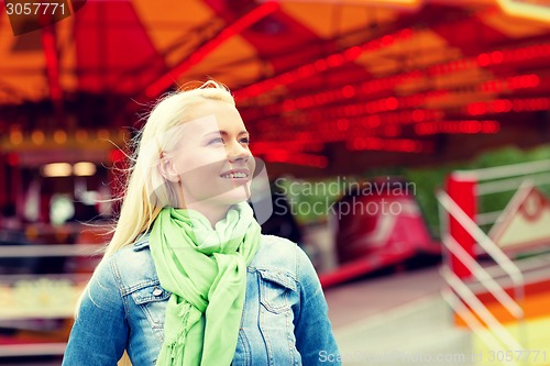 Image of smiling young woman in amusement park