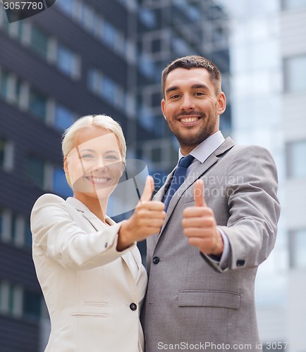 Image of smiling businessmen showing thumbs up