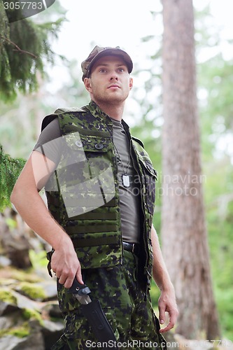 Image of young soldier or hunter with knife in forest