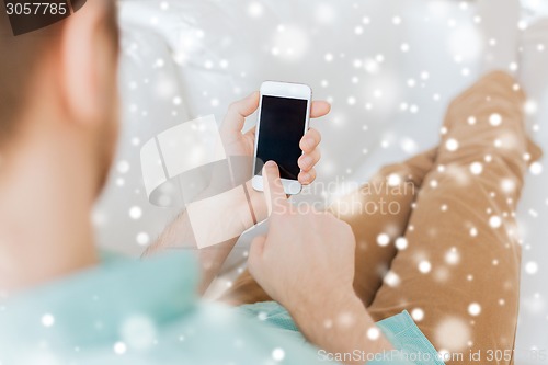 Image of close up of man with smartphone at home