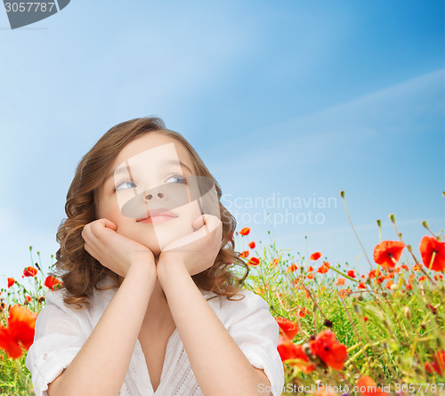 Image of beautiful girl sitting at table and looking up