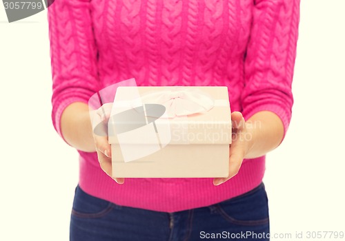 Image of close up of woman in pink sweater holding gift box