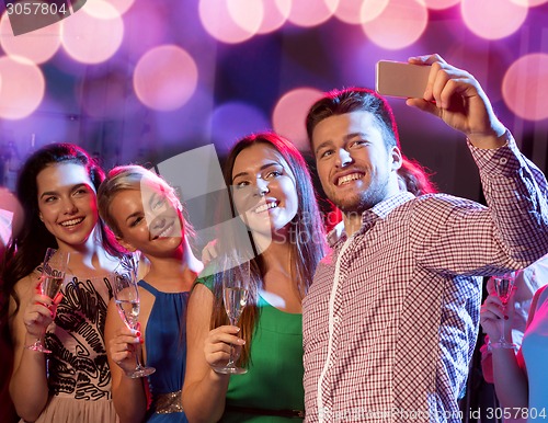 Image of friends with glasses and smartphone in club