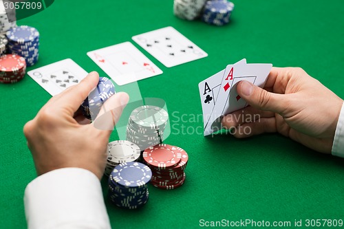 Image of poker player with cards and chips at casino