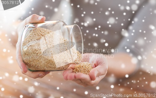 Image of close up of female emptying jar with quinoa