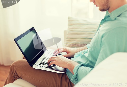 Image of close up of man working with laptop at home