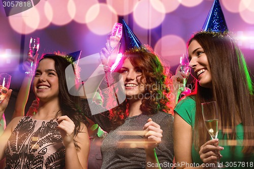 Image of smiling friends with glasses of champagne in club