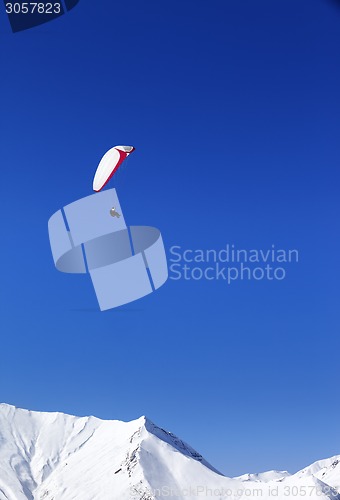 Image of Paraglider in snowy mountains at nice sun day