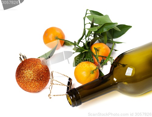 Image of Empty bottle of wine, muselet, mandarins and Christmas decoratio