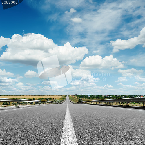 Image of asphalt road with white line on center close up under cloudy sky