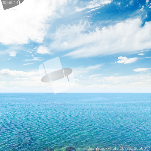 Image of clouds in blue sky over sea