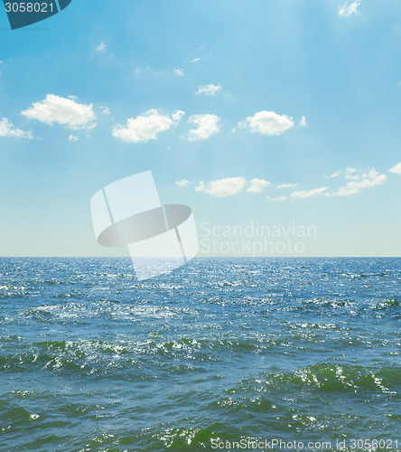 Image of waves on sea and blue sky with clouds