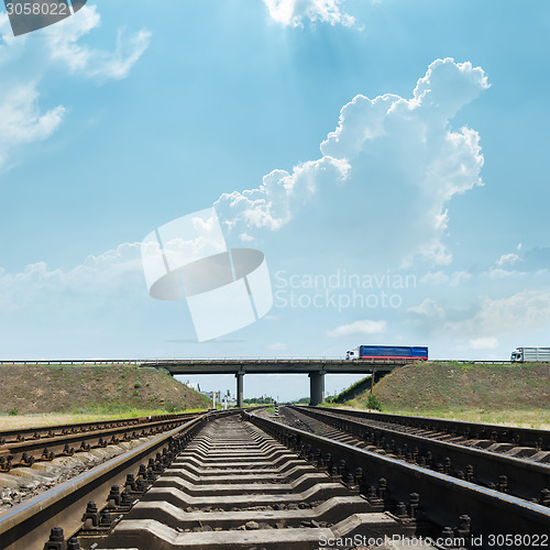 Image of railway goes to horizon under bridge with autos