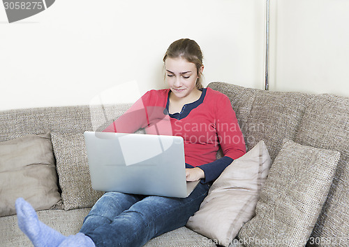 Image of girl with laptop on sofa