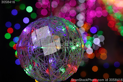 Image of Christmas wire mesh bauble and coloured backgound of defocused l