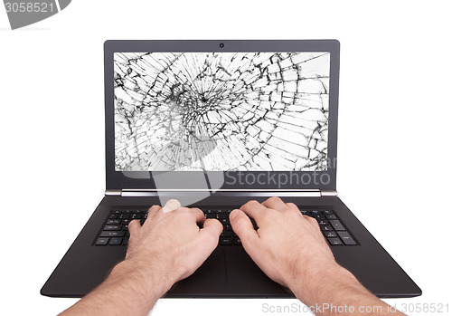 Image of Man working on a laptop with a broken screen