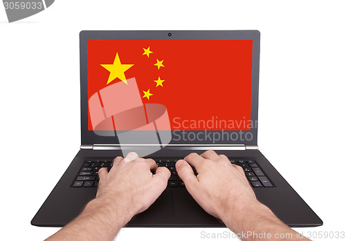 Image of Hands working on laptop, China