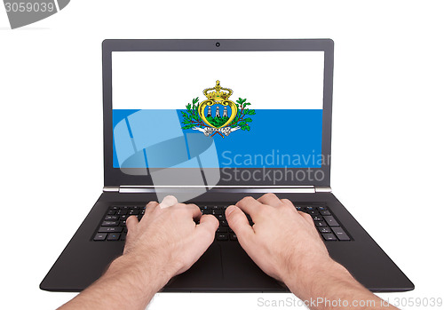 Image of Hands working on laptop, San Marino