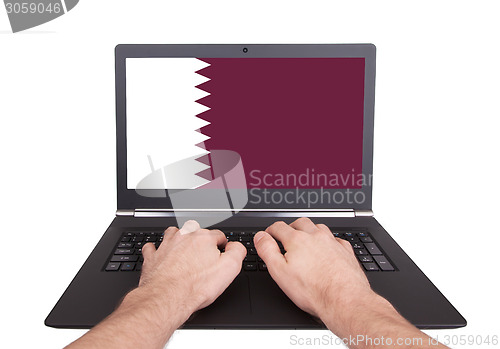 Image of Hands working on laptop, Qatar
