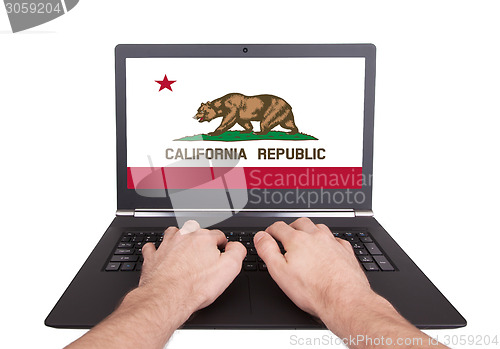 Image of Hands working on laptop, California