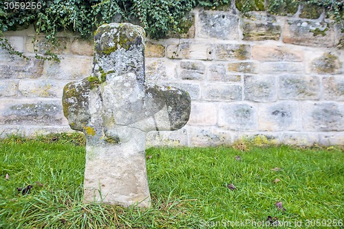 Image of penitence cross with old medieval abbey wall