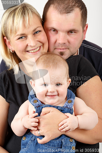 Image of Loving mother and father embracing her baby girl