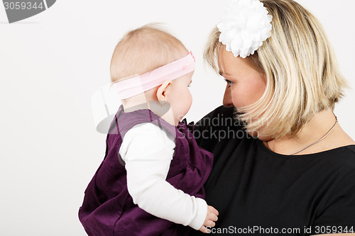 Image of Loving mother embracing her baby girl