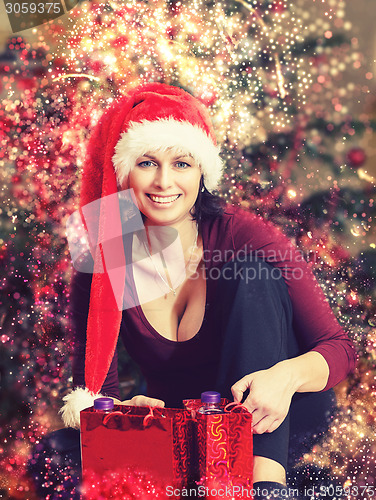 Image of Beautiful middle age woman in santa hat in abstract backgroundCh