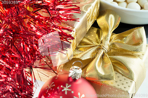 Image of christmas decoration and golden box with ribbon