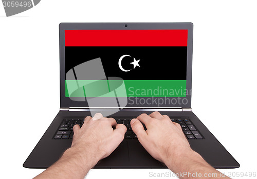 Image of Hands working on laptop, Libya
