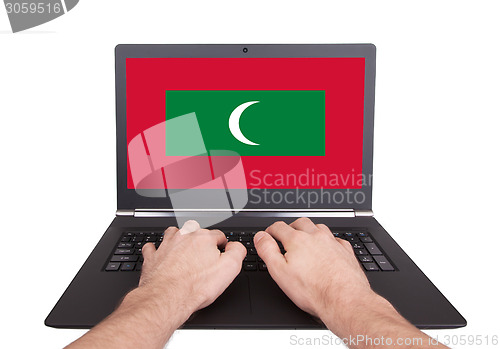 Image of Hands working on laptop, Maldives