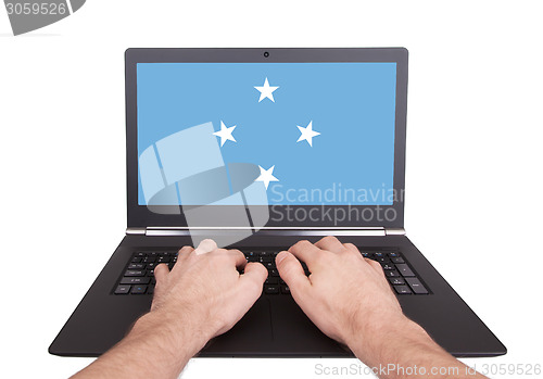 Image of Hands working on laptop, Micronesia