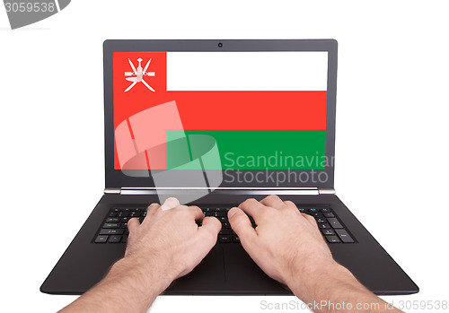 Image of Hands working on laptop, Oman