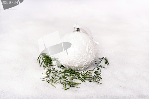 Image of Christmas ball and fir branch with snow