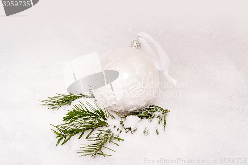 Image of Christmas ball and fir branch with snow