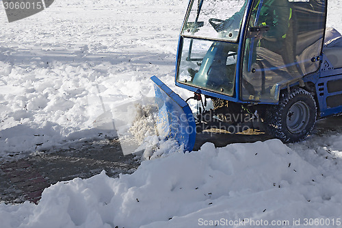 Image of Blue snowplow removing snow