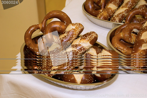 Image of Laugen pretzels and sticks in bowls on a table with white tablec