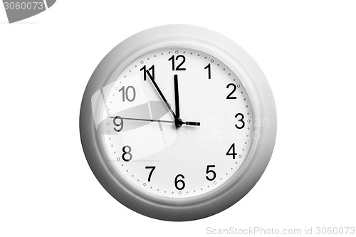 Image of A single simple clock showing the time five to twelve