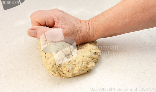 Image of Woman kneading bread dough by hand
