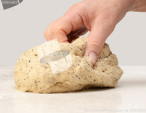 Image of Woman's hand kneading bread dough