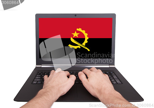 Image of Hands working on laptop, Angola