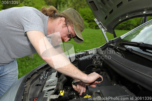 Image of mechanic repairs a car on the road