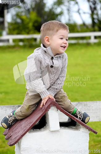 Image of 2 years old baby boy sitting on the little rooftop